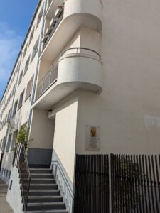 Siatka zainstalowana na półokrągłym balkonie na warszawskim Żoliborzu. Na tle białego budynku siatka balkonowa jest mało widoczna.