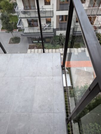 Siatka na balkon prowadzona w dwóch kawałkach. Pierwszy od sufitu do górnej części barierki, drugi od barierki do podłogi balkonu.