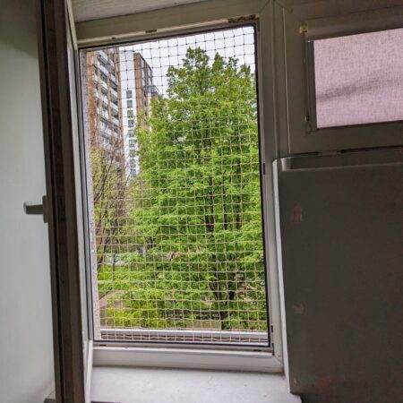Siatka w jednoskrzydłowym oknie na 4 piętrze bloku Warszawa.
