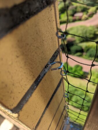 Technika montażu inwazyjnego siatki na balkon. Kołek z hakiem do którego montowana jest siatka balkonowa w Warszawie i okolicach.